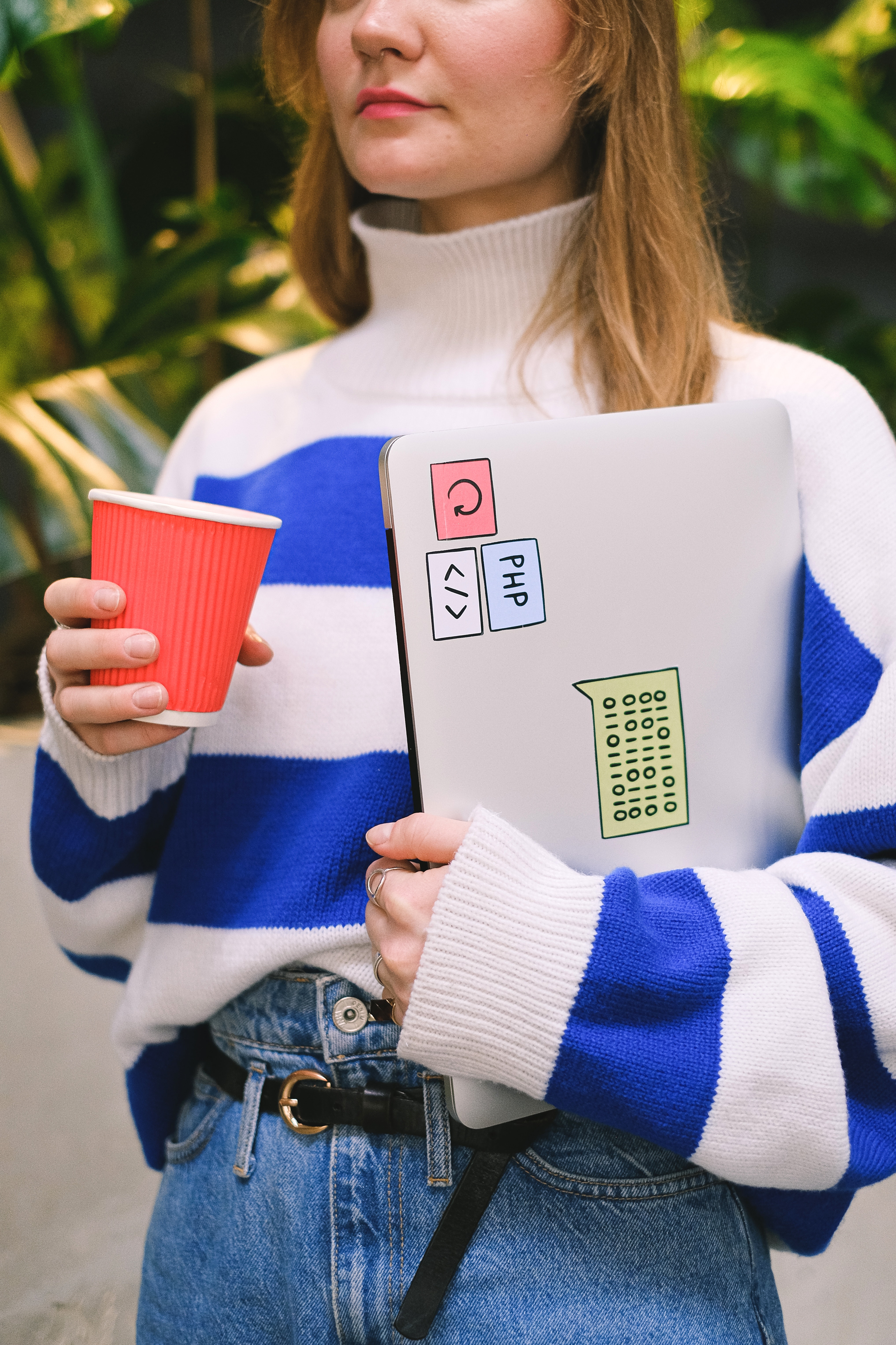 Woman holing a laptop and a cup of koffie